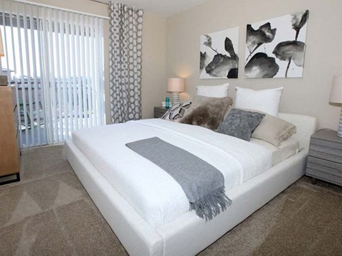 a bedroom with a white bed and a large window