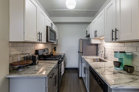 a kitchen with marble counter tops and white cabinets