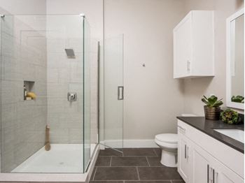 spacious bathroom with glass-framed shower at Tinsley on the Park apartments