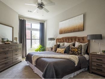 spacious bedroom with expansive windows and a ceiling fan at Tinsley on the Park apartments