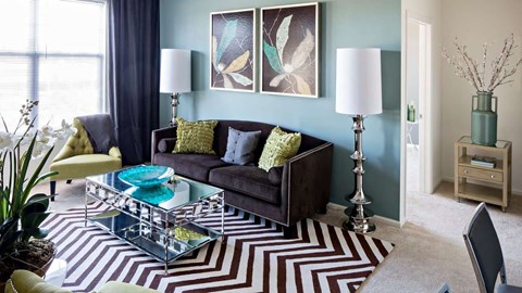 a living room with a couch and a coffee table at Reveal Hackensack apartments