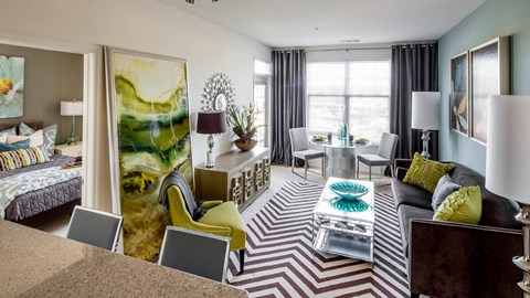 a living room with a couch table and large window at Reveal Hackensack apartments