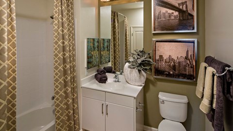 a bathroom with a toilet and a sink and a shower in Reveal Hackensack apartments