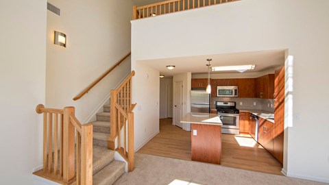 a kitchen and staircase to a second floor at Reveal Hackensack apartments