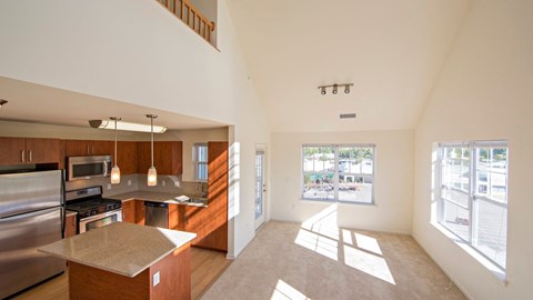 a kitchen and living room with a large window at Reveal Hackensack apartments
