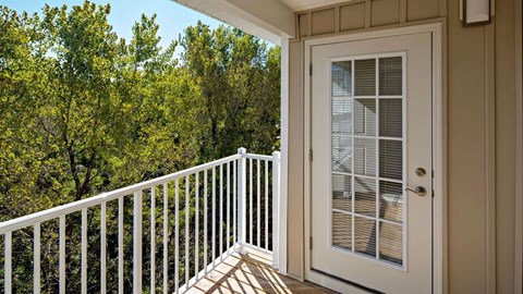 a door on the deck of a unit with trees at Reveal Hackensack apartments