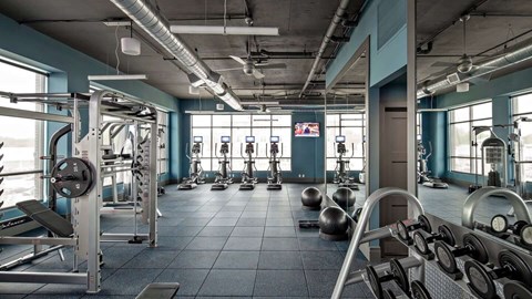 a gym with weights and other exercise equipment at Reveal Hackensack apartments