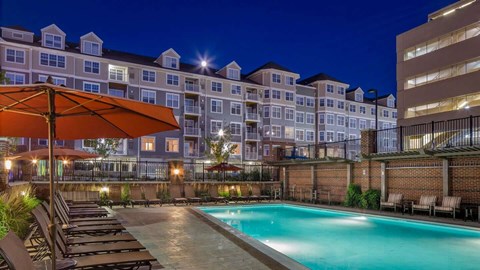 a pool area at Reveal Hackensack apartments at night
