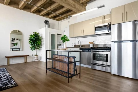 A kitchen with a wooden floor and stainless steel appliances.