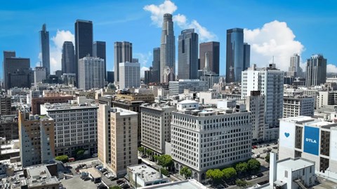 A cityscape with a mix of modern and older buildings under a clear sky.