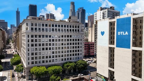 A cityscape with a building that has a heart and DTLA sign on it.