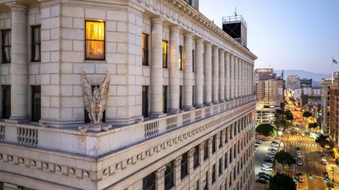 A large building with a statue on the front and a row of windows.