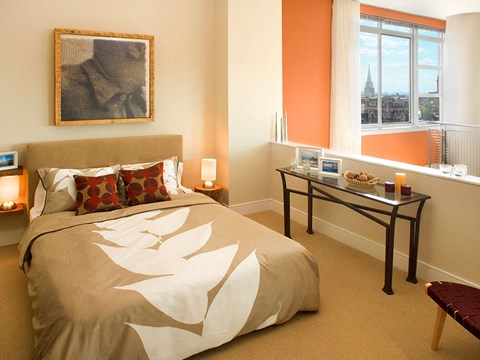 A bedroom with a large bed and a table with food on it.