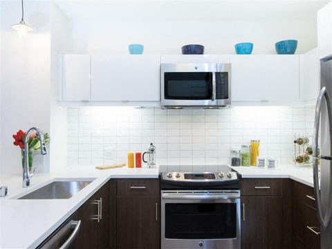 A modern kitchen with a stainless steel oven and microwave.