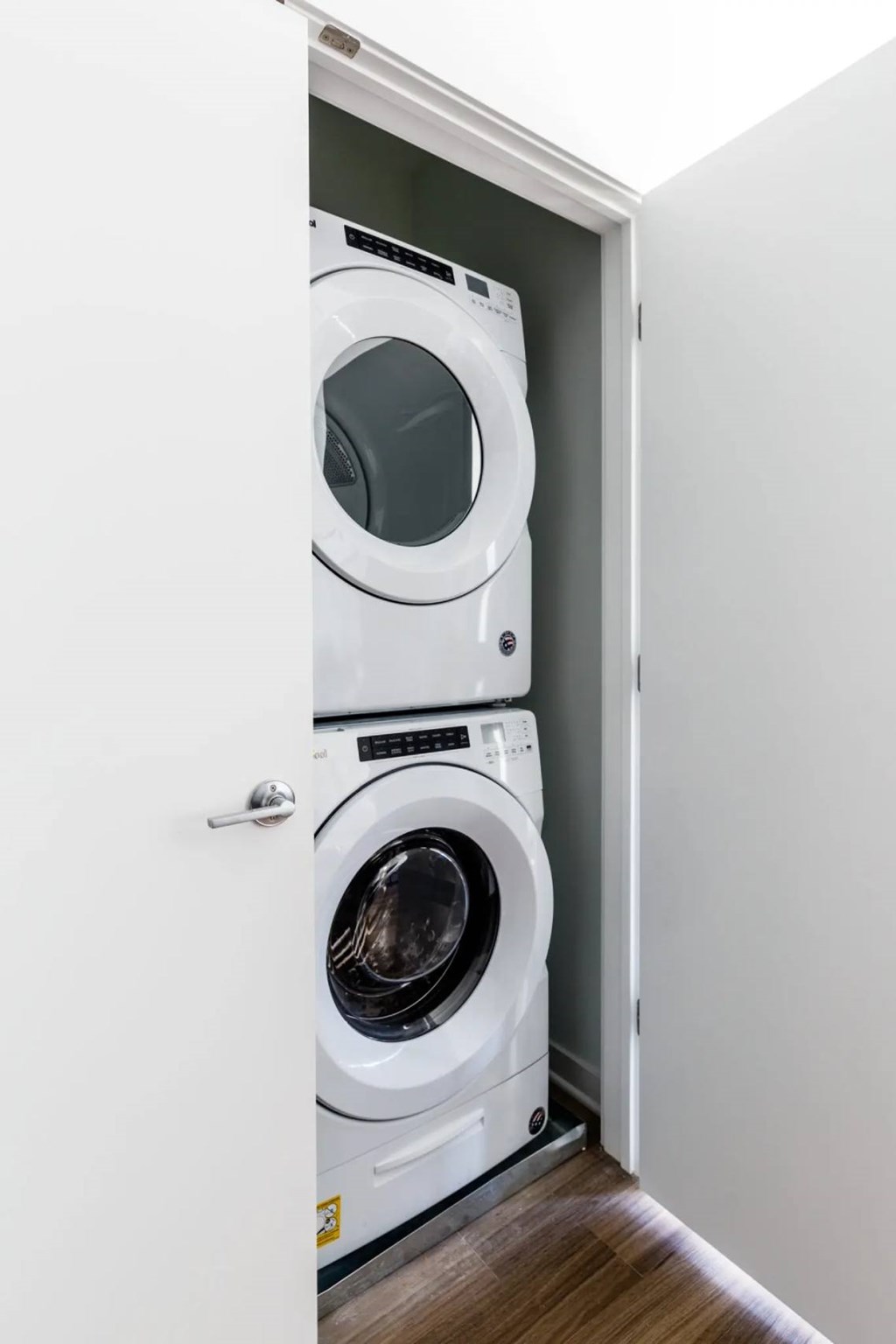 A white washing machine is in a cabinet.