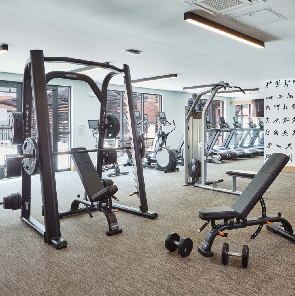 A gym with a variety of equipment including weights and machines.