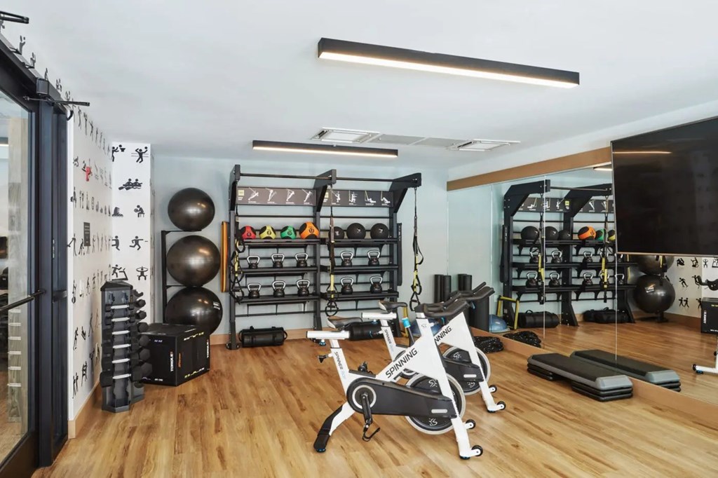 A gym with a variety of equipment including a stationary bike.