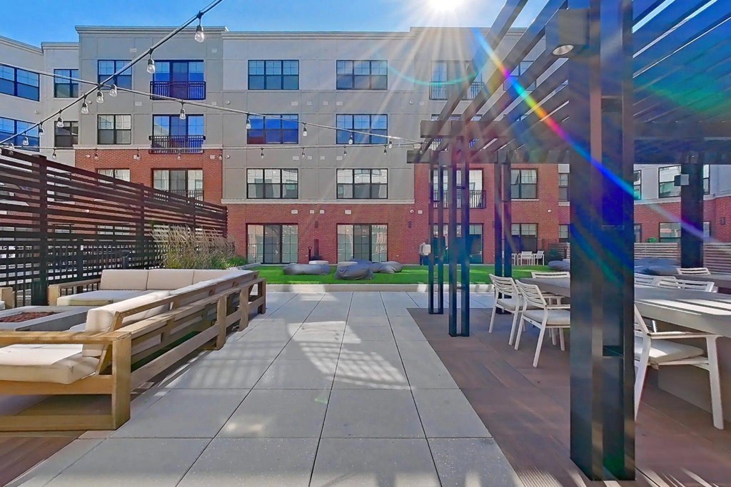 A sunny day at a modern outdoor seating area with wooden benches and tables.