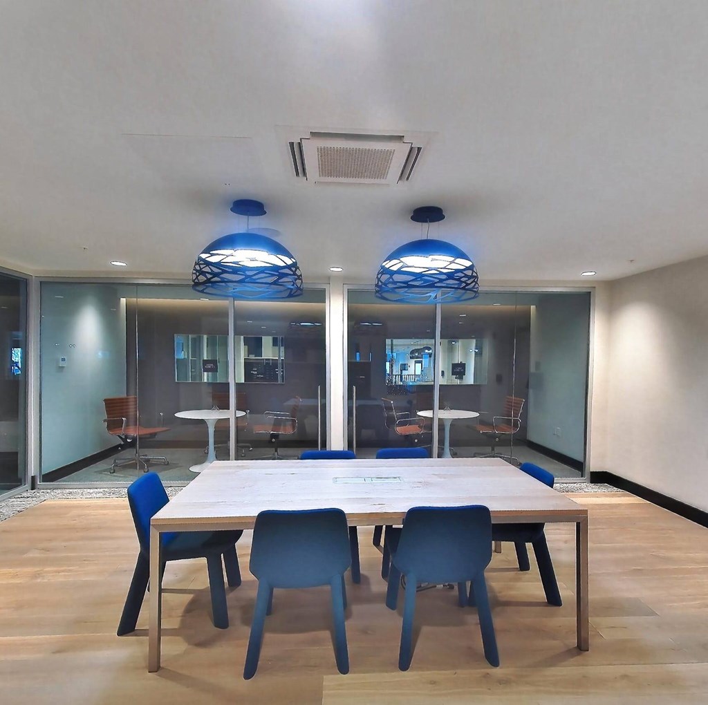 A conference room with a long table and blue chairs.