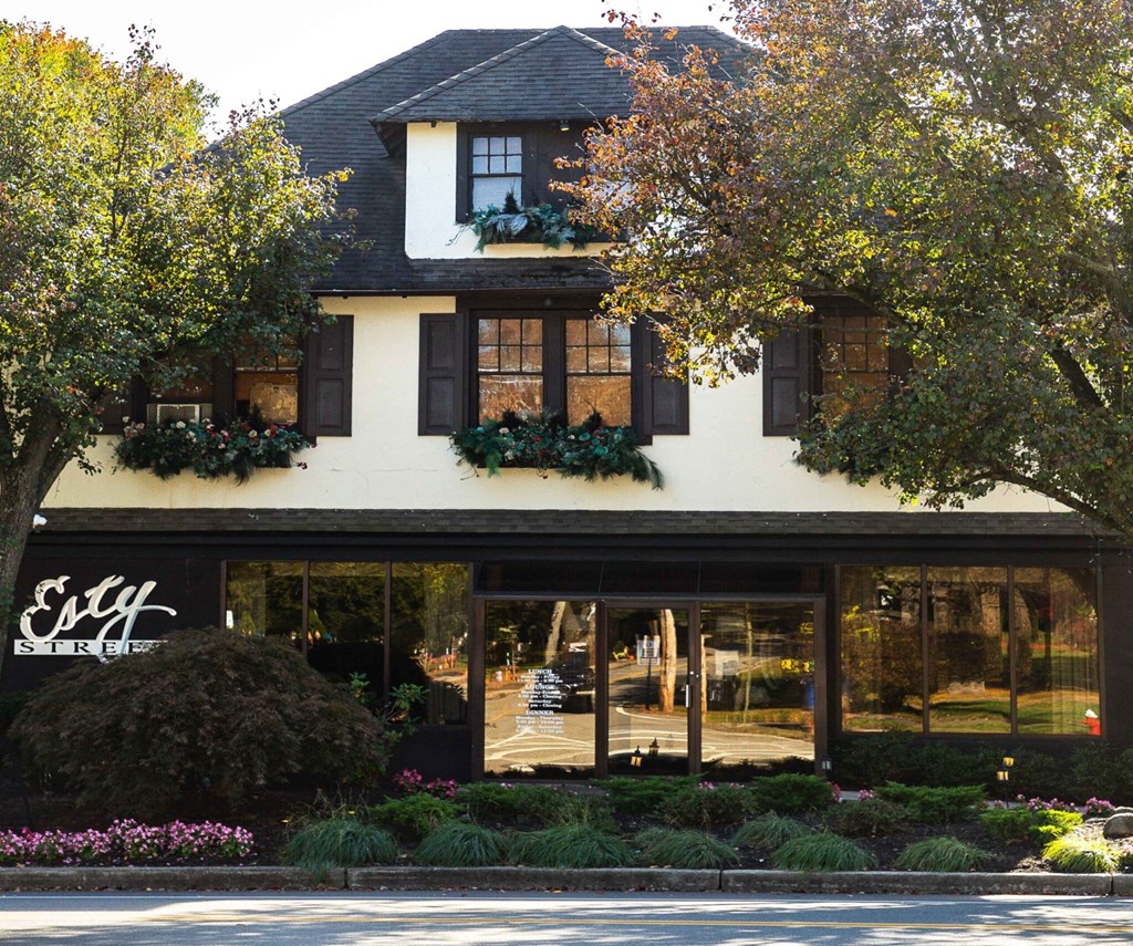 A white building with black shutters and a sign that says "Easy Street".