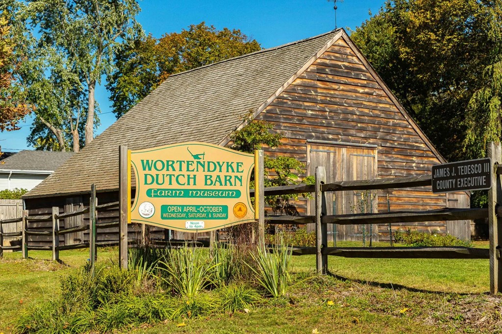 A sign for Wortendyke Dutch Barn is in front of a wooden building.