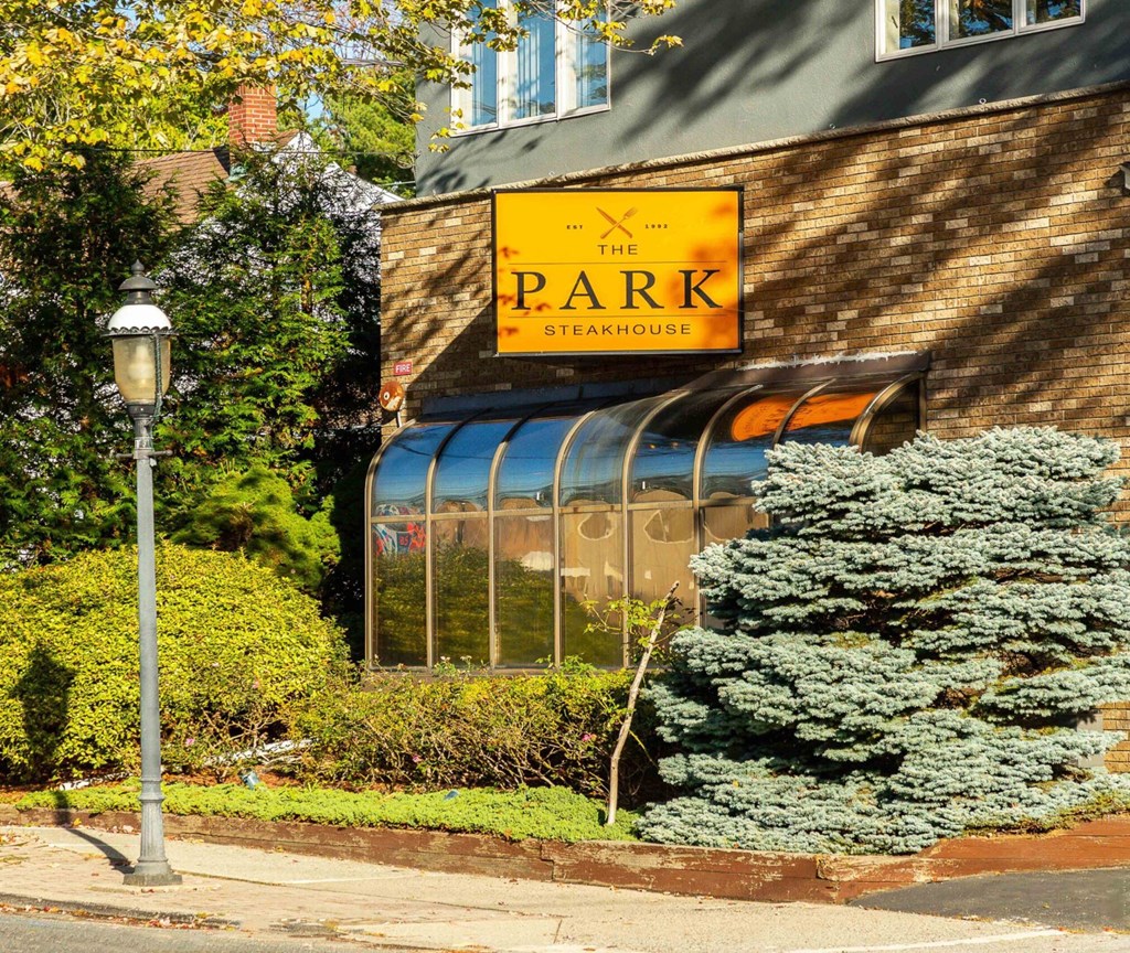 The Park Steakhouse is a restaurant with a brick exterior and a large window.