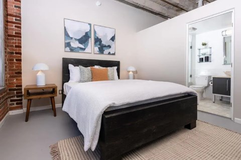 A bedroom with a large bed and a painting on the wall.