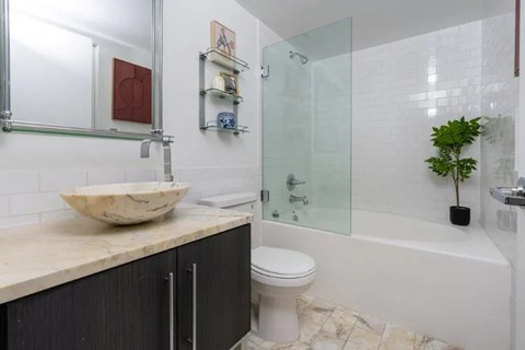 A bathroom with a marble countertop and a white toilet.