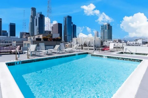 A swimming pool with a city skyline in the background.