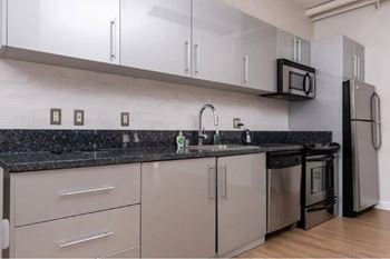 A kitchen with black countertops and white cabinets.