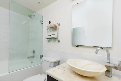 A bathroom with a sink, mirror, and toilet.