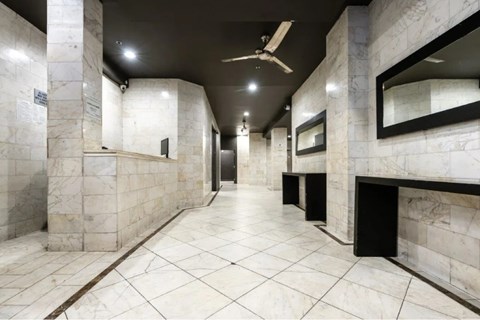 A long hallway with marble floors and walls.