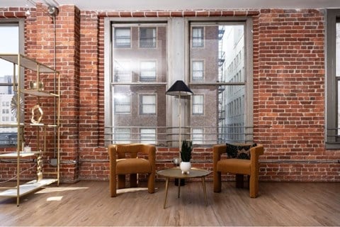 A room with a brick wall and a wooden floor.