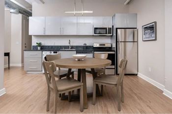 A kitchen with a table and chairs.