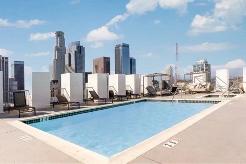 A swimming pool with a city skyline in the background.