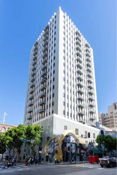 A tall white building with a mural on the side.
