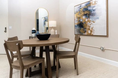A dining room with a round table and chairs.