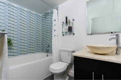 A bathroom with a white toilet, a sink, and a shower with a glass door.