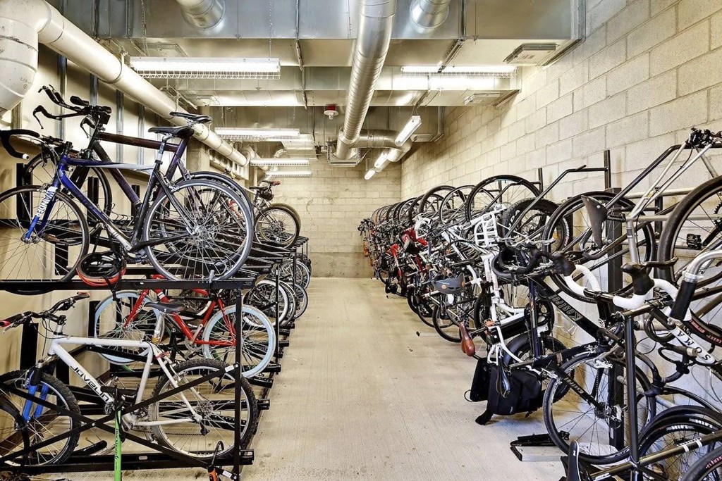 A bike rack full of bicycles in a concrete room.