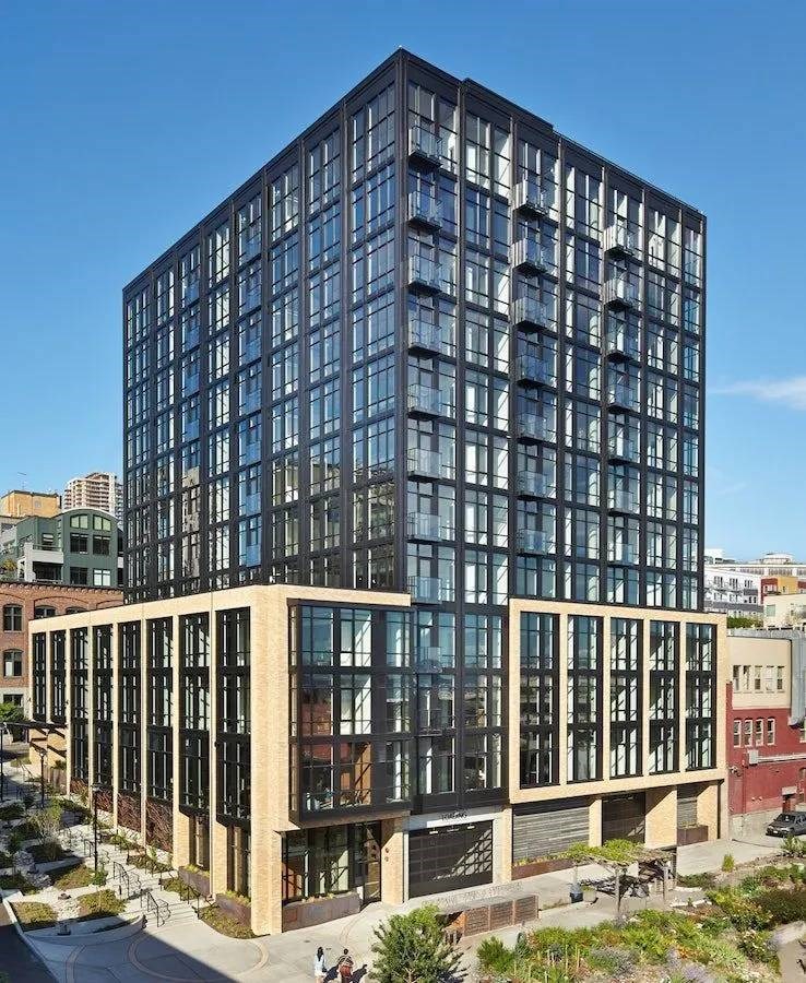 A modern glass and brick building with a clear blue sky in the background.