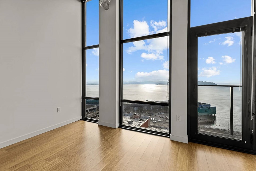 A room with a view of a cityscape through large windows.