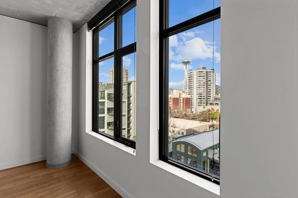 A room with a large window overlooking a cityscape.