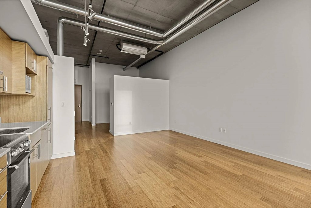 A kitchen area with a stove and wooden floors.