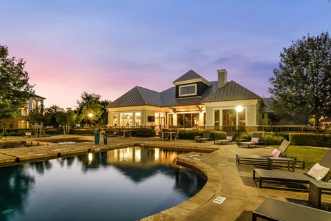 A house with a pool in front of it.