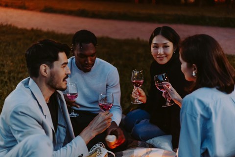 A group of people enjoying a glass of wine together outdoors.
