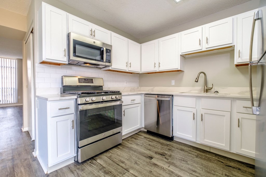 a kitchen with white cabinets and stainless steel appliances