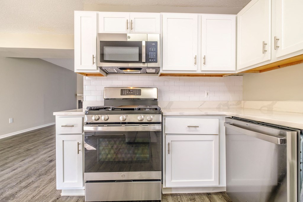 a kitchen with white cabinets and stainless steel appliances