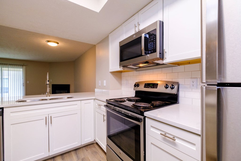 a kitchen with white cabinets and stainless steel appliances