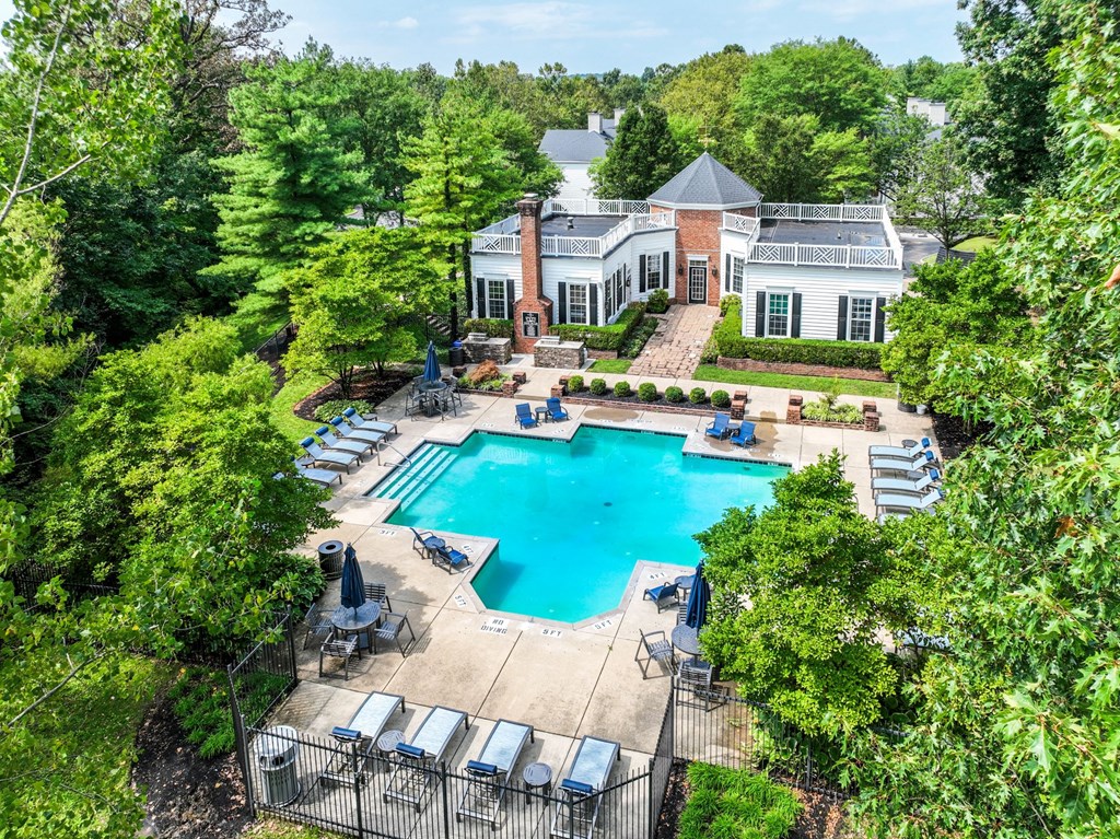 an aerial view of a resort style swimming pool with lounge chairs and umbrellas