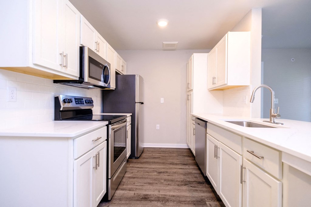 a kitchen with white cabinets and stainless steel appliances